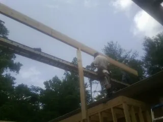 Carpenter setting a ridge beam over a new addition frame — Ice Dam Removal by Roofing Brothers in Sutter Creek