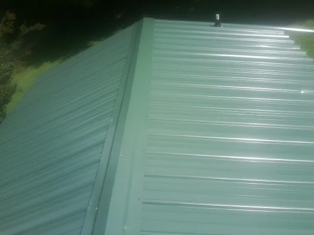New green metal panels meeting at the ridge of a roof in Sutter Creek