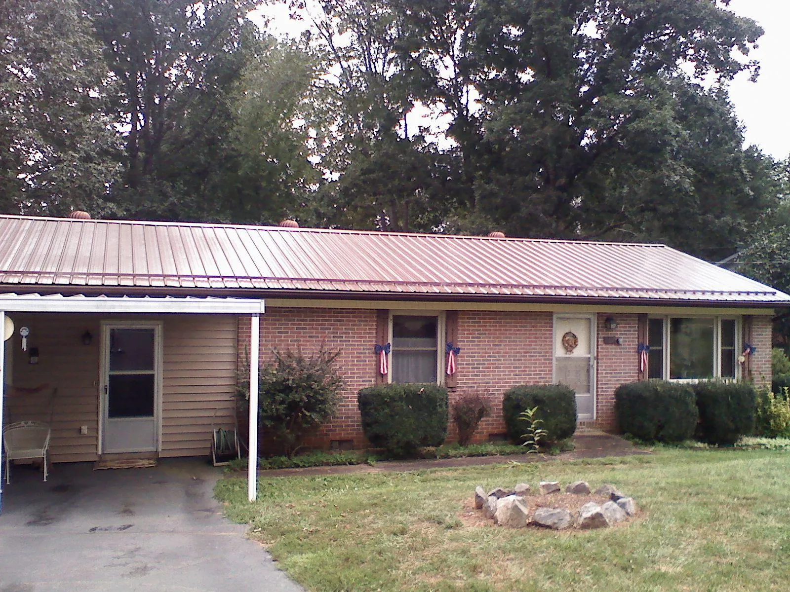 Bronze metal roof and carport on a brick ranch home — Roof Repair work by our crew in Sutter Creek